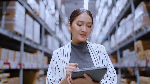 亚洲女企业主的肖像使用数码平板电脑检查库存产品库存数量在配送仓库工厂物流业务运输和配送服务