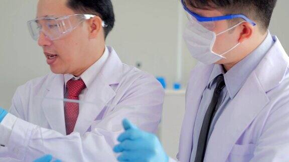 在生命科学实验室工作的卫生保健研究人员年轻男性研究科学家在实验室准备和分析显微镜载玻片科学实验室