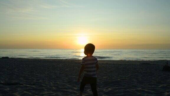 日落时分小男孩在海滩上奔跑