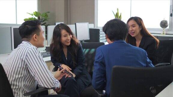 一个年轻的企业多样化的小组聊天八卦在办公室玩