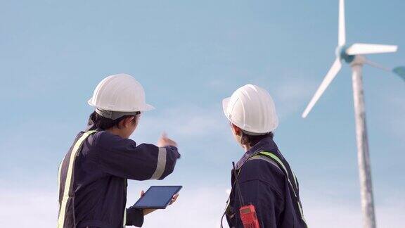 两名技术人员在风力发电场一起检查风力发电机环保为未来的清洁能源