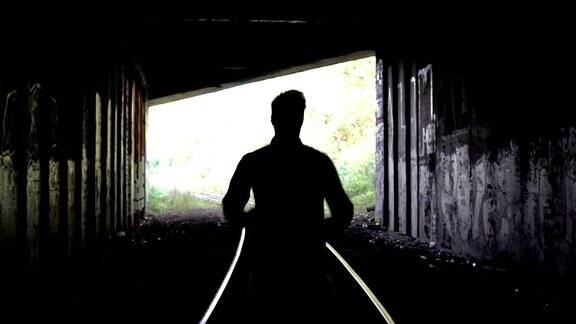 4K失踪男子剪影跑向黑暗的隧道出口后视图抽象的轮廓逃跑问题和抑郁