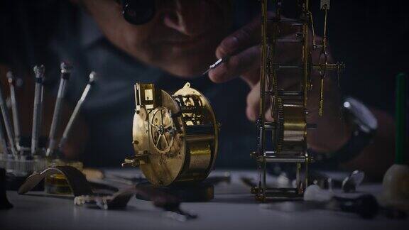 近距离钟表匠检查和修理黄铜模拟钟