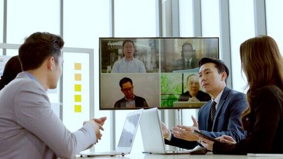 一群亚洲商人通过连接笔记本电脑的屏幕参加视频会议计划实现目标的工作现代会议技术