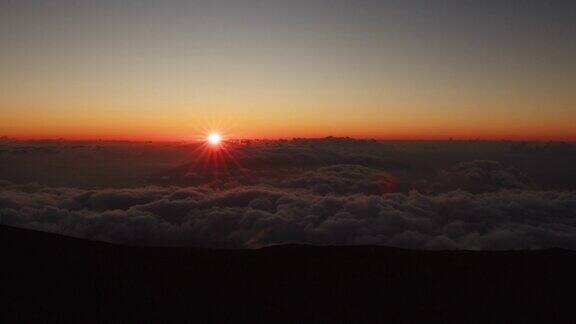 在哈雷阿卡拉山顶太阳落在云层上的时间流逝