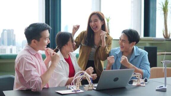 一群亚洲高中生用笔记本电脑制定计划在一个现代的工作场所共同工作空间一个快乐和快乐的人
