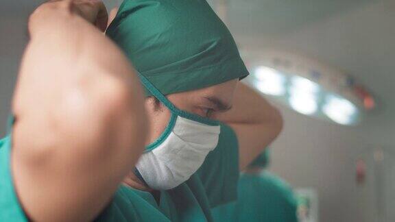 亚洲男性外科医生在手术中戴上医用口罩外科医生准备手术