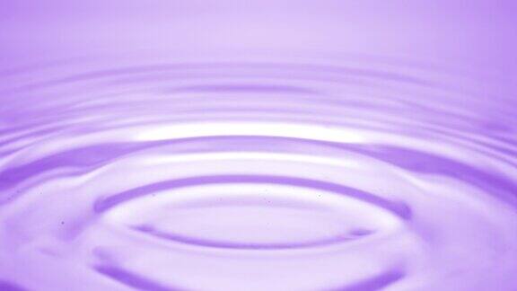 水滴落在紫色的流体表面形成水环