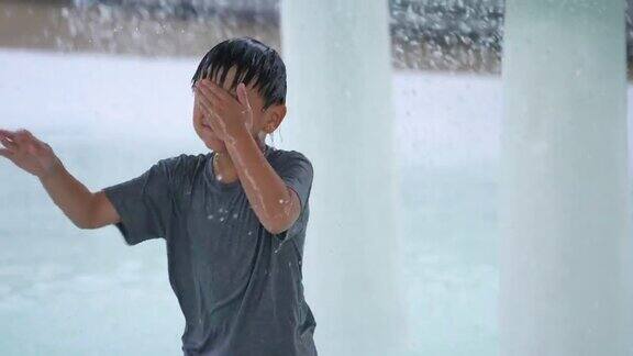 亚洲男孩在室内游泳池和水上公园的水下玩耍和游泳