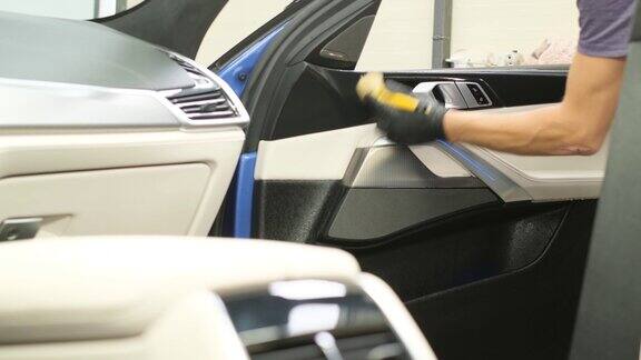 一个男人干洗汽车内部用吸尘器吸汽车内部汽车干洗