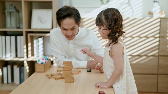 年轻的亚洲父亲和女儿在客厅里玩玩具