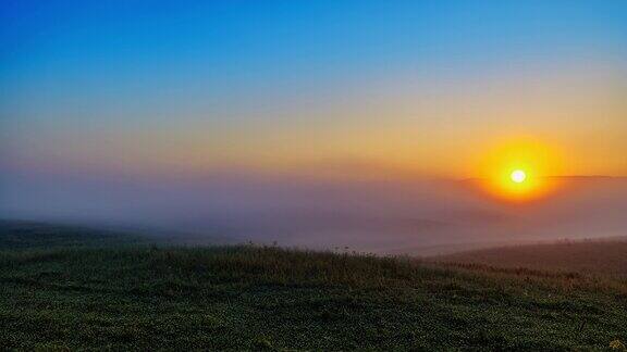 时间流逝飘渺的雾移动在宁静的乡村景观在日出
