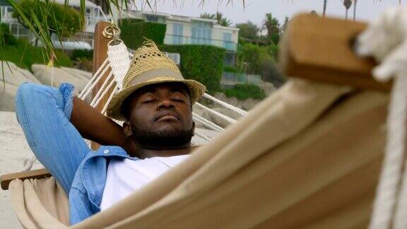 前视图非洲裔美国人睡在一个吊床上的海滩4k