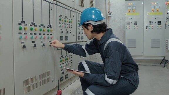 一名电工工程师在工业工厂的控制室、操作站网络中检查和记录电气保护继电器参数