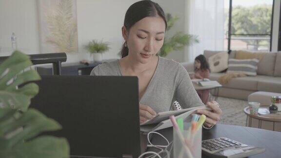 亚洲妇女在家工作带孩子电子学习成人学生班在家上学自由职业新常态概念