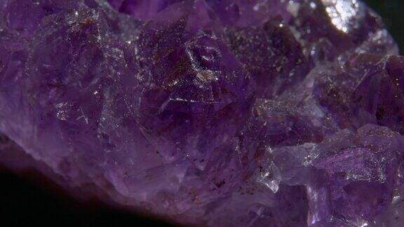紫水晶岩石旋转在黑色背景