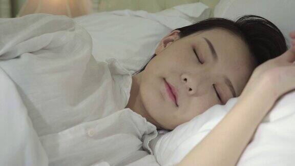 年轻的亚洲女人睡在床上