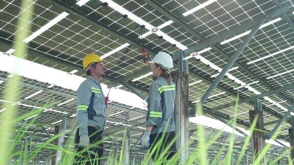 一组电气工程师正在100英亩土地中央的太阳能电池板现场检查和维护太阳能电池板
