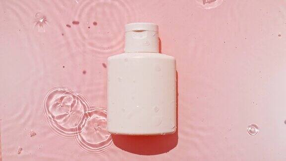 化妆品面霜一瓶乳液精华液胶束爽肤水和乳液在粉红色的水背景与飞溅美容spa医学皮肤护理化妆品的广告