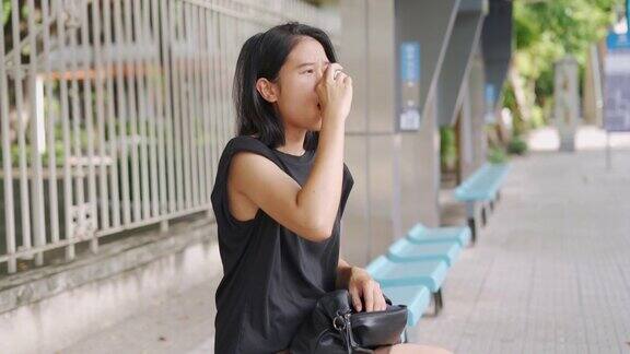 亚洲妇女在公共汽车站使用哮喘吸入器