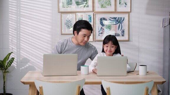 亚洲家庭的商人工作和学生女孩在家学习父亲和女儿在家隔离时在互联网上用在线会议表达快乐呆在家里