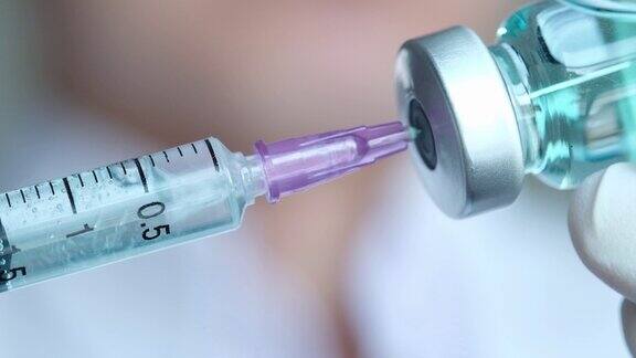 在医院里医生手里拿着注射器和蓝色的疫苗瓶健康和医学概念