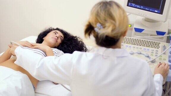 年轻孕妇在医生做超声检查