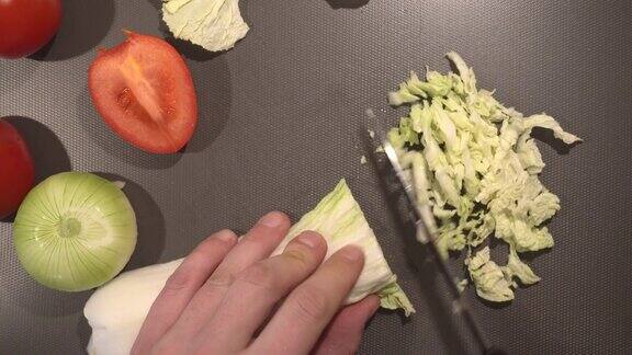 一名男子正在切新鲜的有机大白菜叶做素食菜肴