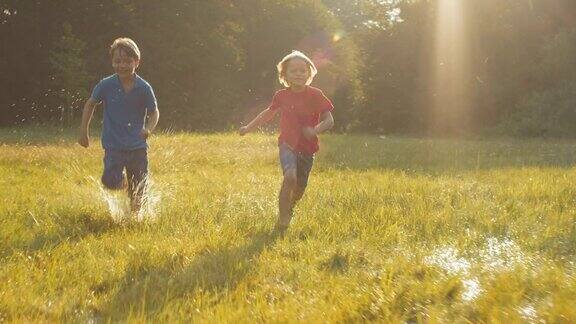 两个快乐的孩子在阳光下赛跑