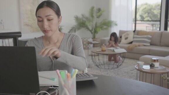 亚洲妇女在家工作带孩子电子学习成人学生班在家上学自由职业新常态概念