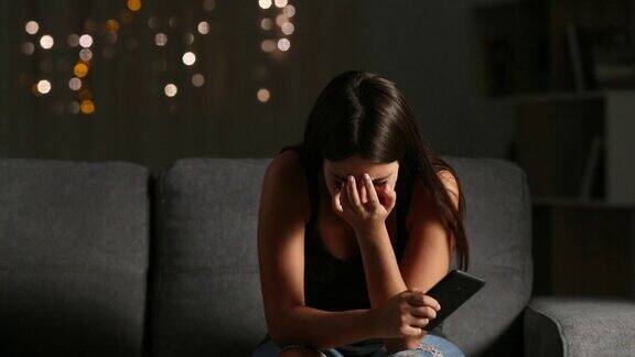 可悲的女孩在看网络欺凌的手机短信