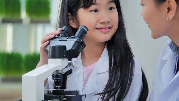 理科学生在学校实验室里看显微镜教师和好奇的学生在教室实验室进行科学实验教育、技术、团队、科学、人本理念教育的主题