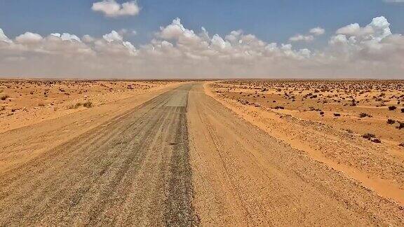 风在突尼斯的沙漠道路上吹沙司机开车时的视角慢动作