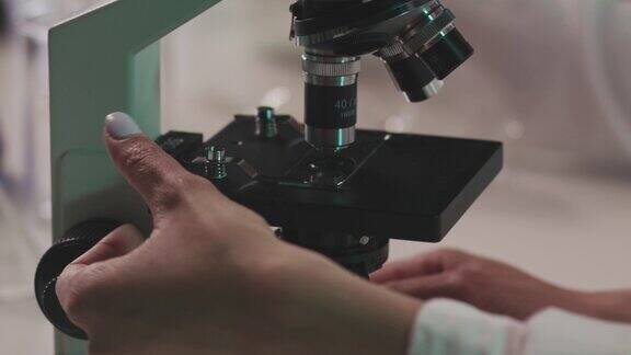 实验室技术人员把载玻片和科学样本放在显微镜下