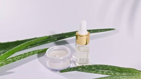 芦荟精油与叶子在白色的背景基于芦荟提取物的化妆品