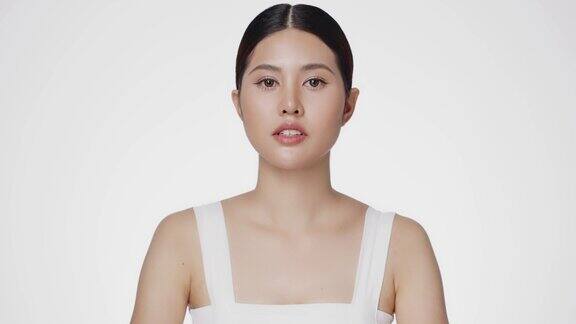 美丽的亚洲女性模特完美的新鲜和干净的皮肤看相机孤立的白色背景皮肤护理治疗或化妆品的广告概念