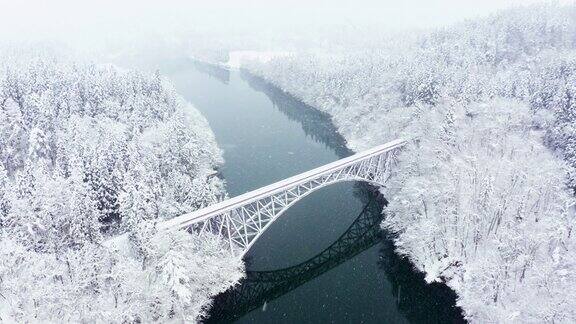 大雪天山间铁路桥的4K鸟瞰图