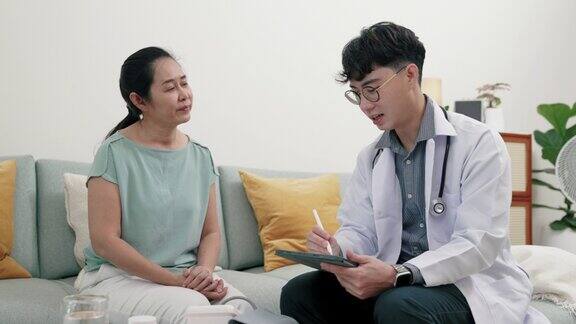 年轻的亚洲男性医生解释他的病人的情况和需要的医疗保健