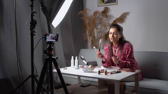 美丽的博主在镜头前展示如何化妆和使用化妆品广告刷化妆在家录制vlog视频直播商业网红
