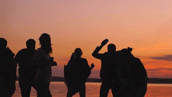 日落时分一群年轻的舞者在海滩上开派对