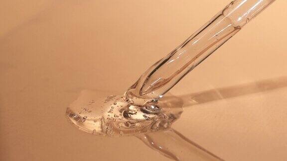 一个玻璃移液管的特写与美容透明液体与气泡玻尿酸护理精华液美容产品