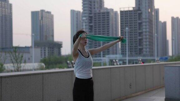 年轻的亚洲女性使用橡皮筋进行户外运动