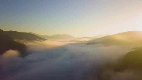 鸟瞰图充满活力的日出在白色的浓雾与遥远的黑色轮廓的山在地平线上