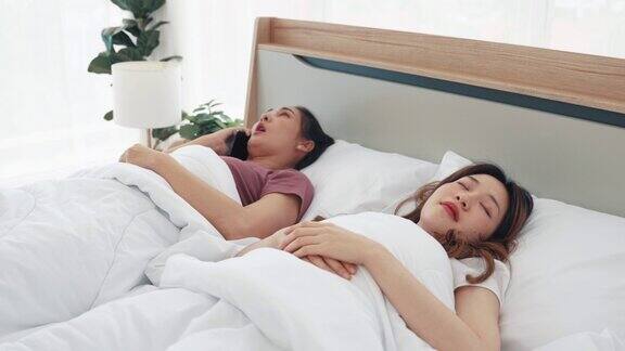 两姐妹睡在床上有一个智能手机打来的电话吵醒了那个女人