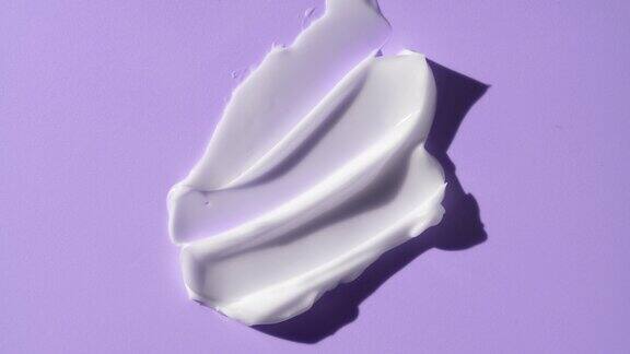 发光奶油涂抹在紫色的背景与移动的光