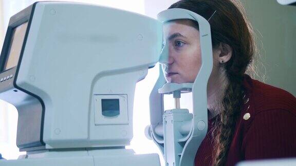 一位女士正在用医疗设备检查她的眼睛