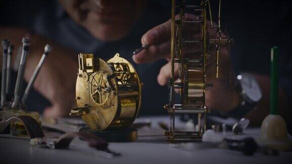接近钟表匠检查和组装黄铜闹钟