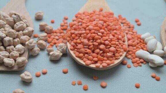 灰色的石头桌上的木勺里放着不同种类的豆子