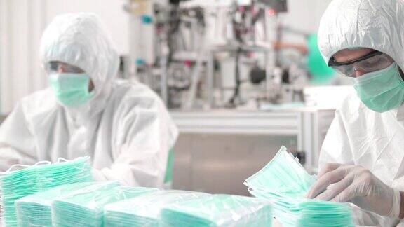 工作人员在防护服在面具厂QC生产线