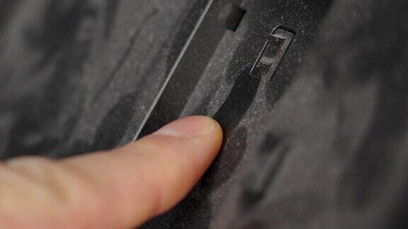 用手指擦拭电子设备黑色表面的灰尘